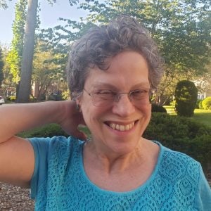 Karen Sussan smiling, outdoors on a summer afternoon