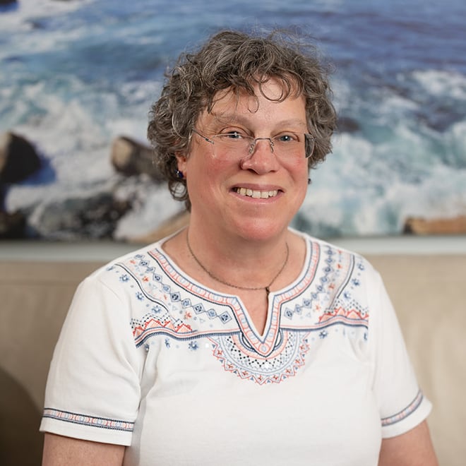 Karen Sussan, LCSW, LMHC, smiling, seated in her Suffern office